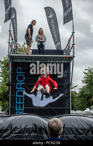 Glasgow Green, Glasgow, Schottland. 03. August 2018. Ein junges Mädchen auf einem grossen Kissen an der Freedrop bei Go Live Skispringen! An der Grünen, Teil des Festivals 2018. Ein Helfer ist an der Oberseite mit der nächsten Brücke und anderen Erwachsenen ist an der Unterseite für Sicherheit. Festival 2018 läuft parallel mit der Europäischen Meisterschaften; Glasgow 2018. Glasgow Green ist ein kostenloses Festival Veranstaltungsort mit vielen Attraktionen aus Give-it-a-go Sport, Musik und Kochvorführungen. Credit: Elizabeth Leyden/Alamy leben Nachrichten Stockfoto