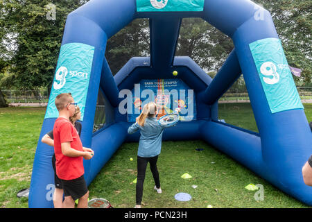 Glasgow Green, Glasgow, Schottland. 03. August 2018. Junge Mädchen übt ihre Tennis dienen in einem Mini-tennis eingerichtet, einer der Haben-ein-go Sport Sitzungen Live gehen! An der Grünen, Teil des Festivals 2018. Zwei Jungen beobachten Sie, während Sie warten. Festival 2018 läuft parallel mit der Europäischen Meisterschaften; Glasgow 2018. Glasgow Green ist ein kostenloses Festival Veranstaltungsort mit vielen Attraktionen aus Give-it-a-go Sport, Musik und Kochvorführungen. Credit: Elizabeth Leyden/Alamy leben Nachrichten Stockfoto