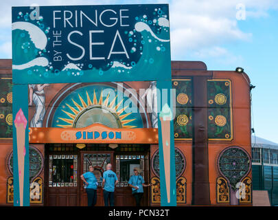 North Berwick, Schottland, Großbritannien. August 2018. Menschen am Eingang zu Fringe by the Sea im Hafen von Nord-Berwick, der heute eröffnet wird. Die Shows finden an Veranstaltungsorten in der Stadt statt, wobei zwei Spiegelzelte von Simpson & Marwick Immobilienmaklern gesponsert und nach ihnen benannt werden Stockfoto