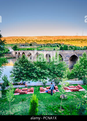 Nicht identifizierte Personen sitzen in der Nähe von zehn eyed Brücke, eine beliebte Sehenswürdigkeit im Zentrum von Diyarbakir, Türkei. vom 16. Juli 2018 Stockfoto