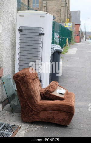 Hausmüll einschließlich einen Stuhl und frisge Gefrierschrank in der Straße links Stockfoto