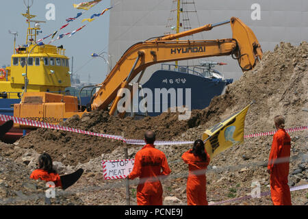 Wie Bulldozer in das Land der vorgeschlagenen Walfleisch Verarbeitungsanlage und wissenschaftlichen Forschungszentrum zu glätten, vor einem Wal catcher Schiff auf Anzeige, Greenpeace Aktivisten besetzen Teil der Website. Die Greenpeace 'Wal Botschaft" hat, der die Website einer vorgeschlagenen Wal Forschungseinrichtung und Fleischverarbeitungsbetrieb gewesen, und die Aktivisten weigern sich zu verlassen, bis die Pläne für den Standort storniert sind. Die Aktivisten wurden bestellt das Land bis zum 16. Mai 2005 zu räumen, sondern haben sich geweigert, dies zu tun. Stockfoto