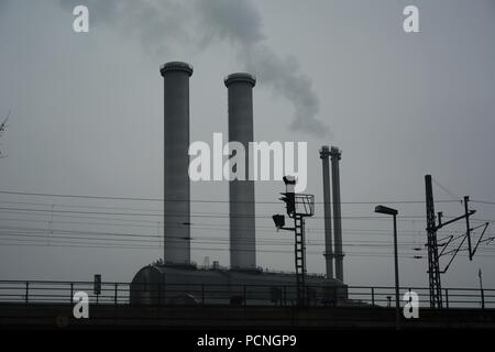 Fabrikschloten rauchend über die Stadt auf eine dunkle und trübe Tag Stockfoto