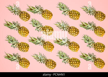 Isolierte Ananas Muster auf hellen roten Hintergrund. Sommer Konzept von Frische reife ganze Ananas Schuß von oben Stockfoto