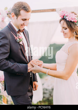 Sensible Outdoor Portrait von die schöne Braut die Hochzeit Ring am Finger des Bräutigams. Stockfoto