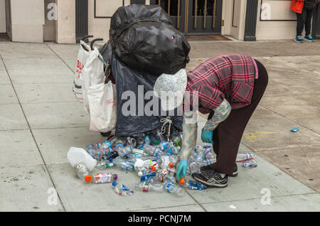 Eine ältere Frau war Sortieren aus Plastikflaschen für Recycling, San Francisco, Kalifornien, USA Stockfoto