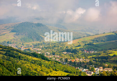 Schönen bergigen Landschaft. Dorf im Tal. schöne helle Herbst morgen mit tiefen Wolken und Dunst Stockfoto