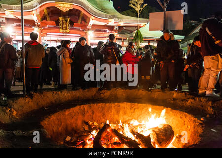 CShogatsu, neues Jahr, Nishisnomiya Schrein, Japan. Leute um Lagerfeuer verwendet alte Glücksbringer zu brennen, bei Ihrem ersten Besuch, Hatsumode Stockfoto