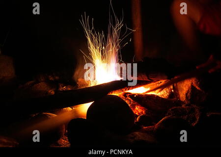 Funken aus einem Protokoll brennenden Lagerfeuer nachts in schwarz