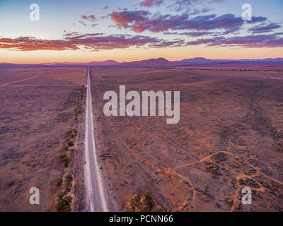 Gerade ländliche Straße in der Ferne in der Abenddämmerung verschwinden. Flinders Ranges, South Australia Stockfoto