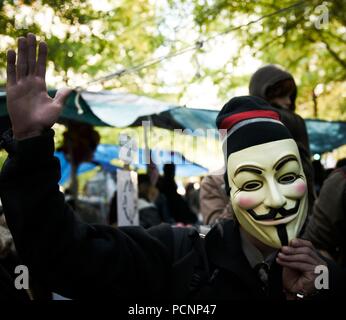 Demonstrant Tragen eines V für Vendetta Guy Fawkes Maske. Besetzt die Wall Street Protest und Bewegung, im Zuccotti Park, Wall Street New York. Stockfoto