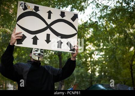 Demonstrant Tragen eines V für Vendetta Guy Fawkes Maske. Besetzt die Wall Street Protest und Bewegung, im Zuccotti Park, Wall Street New York. Stockfoto