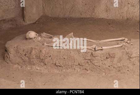 Zimmer mit unheimlichen verfallenen menschlichen Skelett in die Verlegung in schmutziger Sand Stockfoto