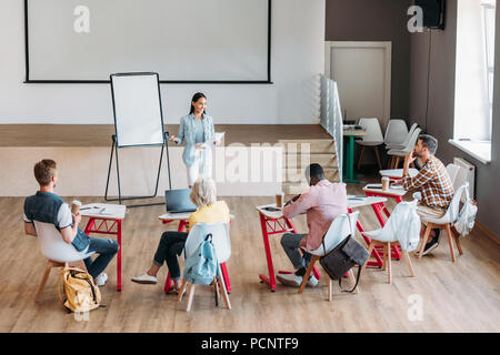 Gruppe junger Schüler sitzen in der Klasse und hören Vortrag Stockfoto