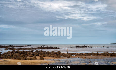 FUNDAO, Espirito Santo, Brasilien - 30. Juni 2018: ein einsamer Fischer wirft seine Fischernetz in Strand Praia Grande. Stockfoto