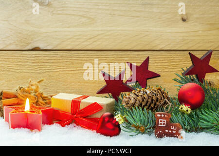 Weihnachtsdekoration in den Schnee vor Holz Stockfoto