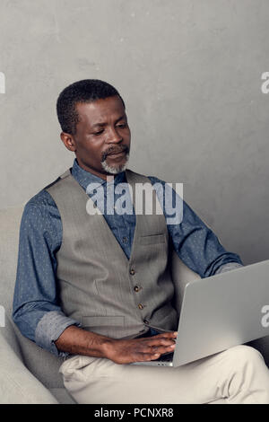 Schwere reifen afrikanische amerikanische Geschäftsmann mit Laptop bei der Arbeit Stockfoto