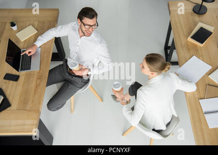 Ansicht von oben Der junge Geschäftsleute mit Papier Tassen Kaffee sitzen im Büro Stockfoto