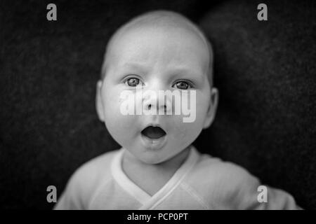 Baby mit geöffnetem Mund erstaunt suchen, Porträt, s/w Stockfoto