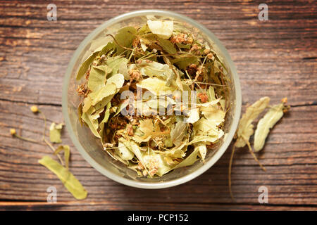 Getrocknete linden Blume in einem Glas, Linde Tilia Blätter und Blüten auf hölzernen Tisch Stockfoto