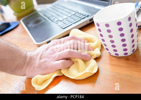 Hand Reinigung Schreibtisch mit gelben Tuch zu Hause Stockfoto