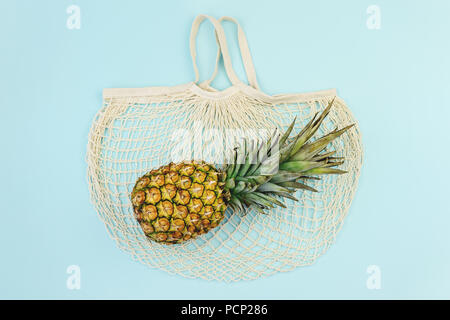 Farbenfrohe Sommer Shopping-legen. Reife Ananas über Baumwolle Mesh bag, Ansicht von oben, kopieren. Sommer Shopping verkauf Routine und Urlaub Stockfoto