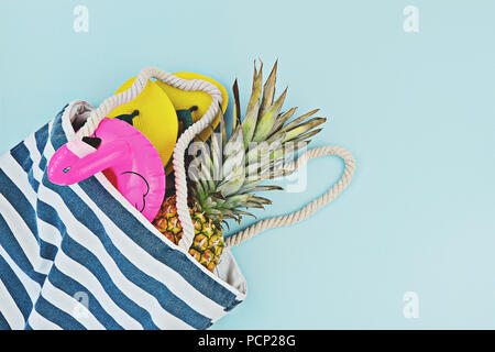 Farbenfrohe Sommer Pool oder Strand flach. Schwebte aufblasbarer Flamingo, Flip-Flops, Ananas über blauen Hintergrund, Ansicht von oben, kopieren. Sommerzeit Stockfoto