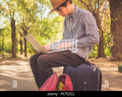 Portrait Junge männliche Touristen arbeiten an saptop in der Stadt. Stockfoto