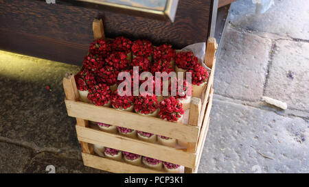 Kleine Töpfe mit rote Rosen auf Holzkisten in einer Ecke auf dem Boden gestapelt Stockfoto