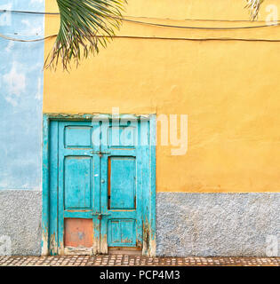 Alte, nicht verwendete malerischen Holztür mit bunten Haus Wand in Spanien, Europa. Stockfoto