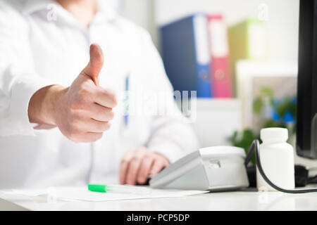 Arzt zeigt Daumen nach oben. Gerne doc, Arzt, eine Krankenschwester oder der Arzt. Arzt zeigt positive Geste im Krankenhaus Büro und Zimmer. Stockfoto