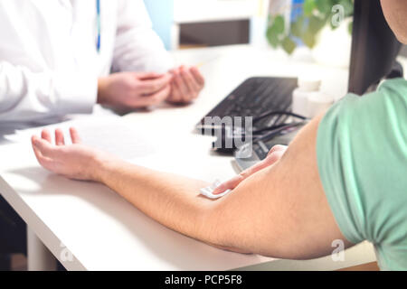 Blutprobe, Muster oder Spende Konzept. Arzt und Patient im Krankenhaus, Notaufnahme oder Labor. Person, die Tupfer auf den Arm. Stockfoto