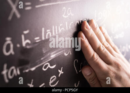 Fehler machen und falsche Antwort Konzept. Abwischen der Hände mathematische Formel aus Tafel im Klassenzimmer in der Schule. Schüler oder Lehrer zu korrigieren. Stockfoto