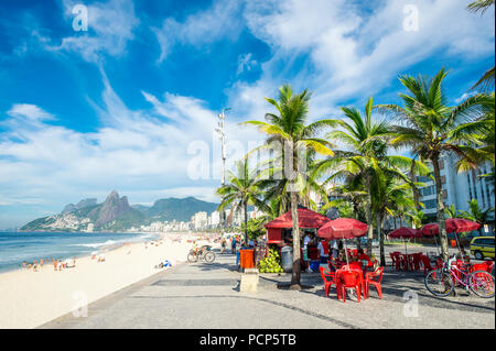 Hellen morgen Blick auf einen Kiosk und Palmen auf der Promenade mit den Ipanema Strand und zwei Brüder Bergkulisse. Stockfoto
