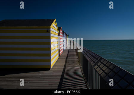 Bunt gestreiften Strand Hütten auf der Pier von Hastings, East Sussex, England Stockfoto