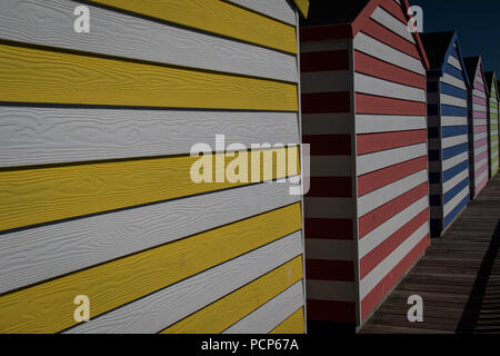 Bunt gestreiften Strand Hütten auf der Pier von Hastings, East Sussex, England Stockfoto