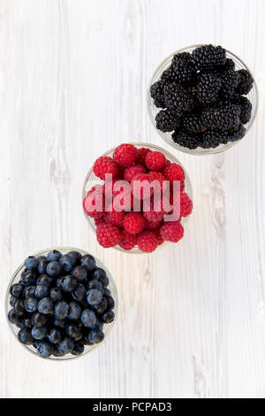 Drei Schalen mit Beeren: Blaubeeren, Brombeeren, Himbeeren. Gesunde Ernährung und Diät. Von oben, Overhead, Ansicht von oben. Stockfoto