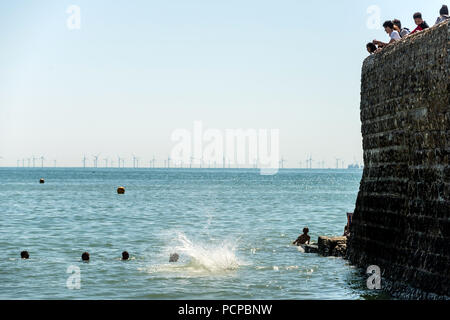 Junge Menschen genießen Sie eine Abkühlung am Brighton Beach am späten Nachmittag Rekordtemperaturen Stockfoto