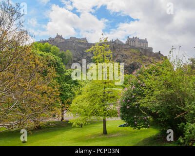 Die Burg von Edinburgh in Schottland, UK von der Princes Street Gardens auf einem hellen, sonnigen Tag gesehen. Stockfoto