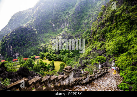 Auf der Suche nach Touristen kommen Sie die Treppe vom Mua Höhleneingang. Stockfoto