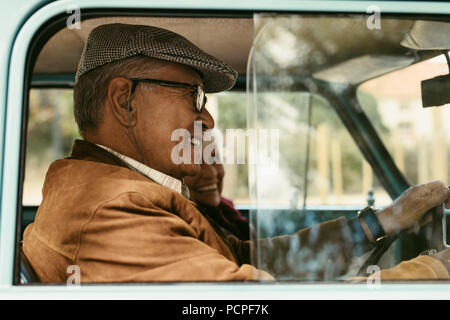 Happy senior Wan das Fahren eines Autos mit Frau saß auf dem Beifahrersitz. Senior Paar heraus auf einem Laufwerk. Stockfoto
