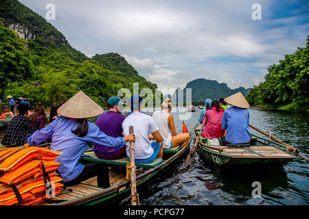 Eine Gruppe von Touristen in zwei Boote verlassen den Docks für Ihre Bootsfahrt durch die Höhlen. Stockfoto