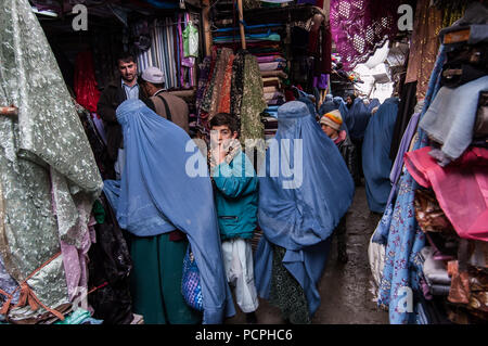 Kabul, Afghanistan, März 2005: Frau mit Tuch in Kabul Marktstand Stockfoto