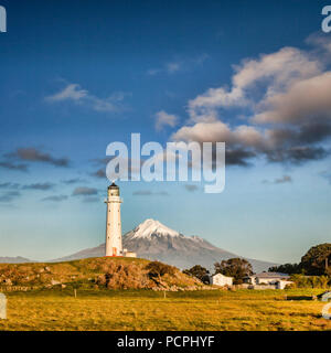 Mount Taranaki, auch als Mount Egmont, und Cape Egmont Lighthouse, Taranaki, Neuseeland, bei Sonnenuntergang bekannt. Stockfoto
