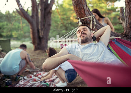 Partei, Camping von Männern und Frauen Gruppe am Wald. Sie entspannende und kochen Grill Stockfoto