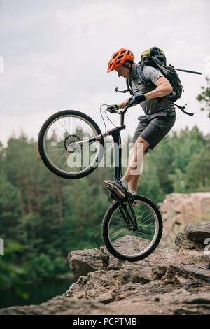 Extreme Trial Biker stehen auf Hinterrad auf felsigen Klippe Stockfoto