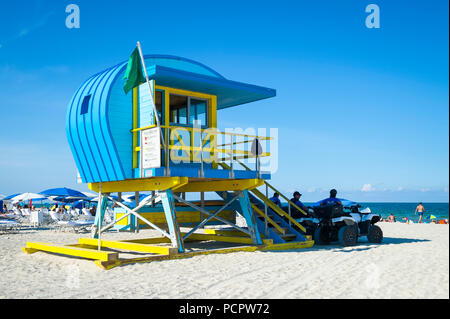 Malerischer Blick auf eine ikonische Gelb und Blau lifeguard Tower und Sonnenschirme am Strand von South Beach, Miami Stockfoto