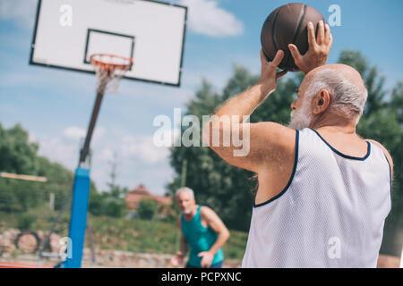 Ältere Männer zusammen Basketball spielen auf dem Spielplatz im Sommer Tag Stockfoto