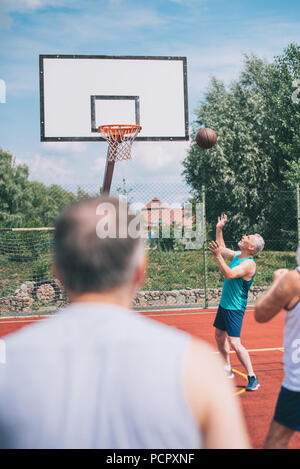 Ältere Männer zusammen Basketball spielen auf dem Spielplatz im Sommer Tag Stockfoto