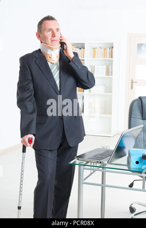 Geschäftsmann am Arbeiten tragen Nackenschutz mit Krücken Stockfoto